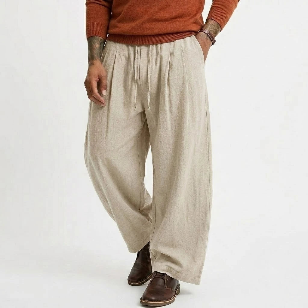 Pantalones casuales de lino beige para hombre, con cintura ajustable mediante cordón y corte relajado de pierna ancha, confeccionados en algodón.
