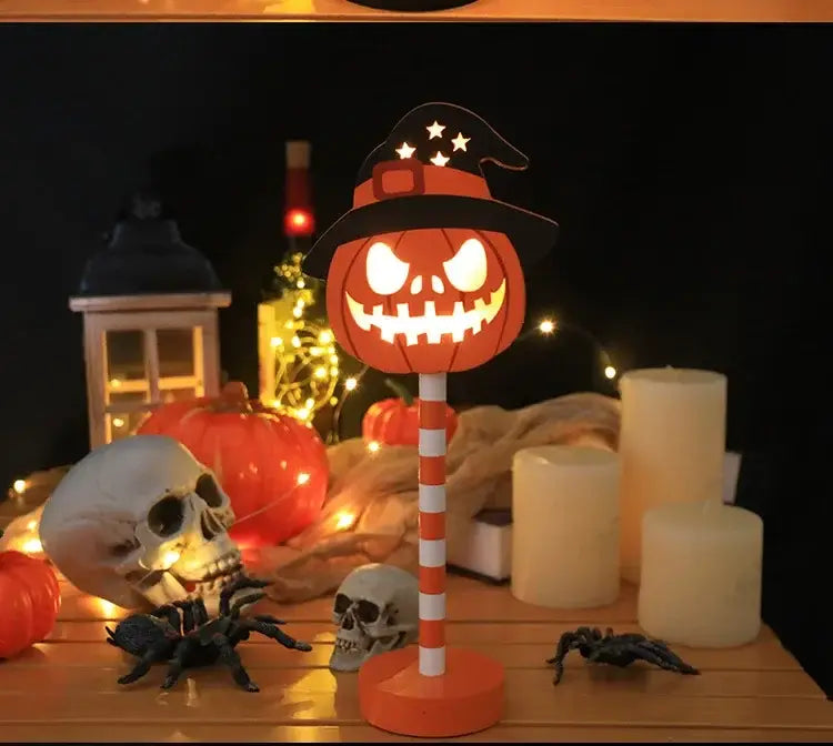 Halloween-LED-Nachtlicht mit Wasserschutz-Dekoration, mit einer orangefarbenen, kürbisförmigen Lampenform mit schwarzem Hexenhut, verziert mit weißen Sternen, montiert auf einem orange-weißen, gestreiften Stab.
