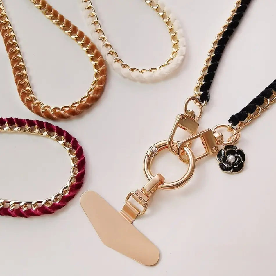 Handy-Handgelenkriemen aus goldfarbener Kette mit schwarzem geflochtenem Kord und floralen Anhänger-Anhänger für Anti-Lost-Handylanyard-Verwendung.