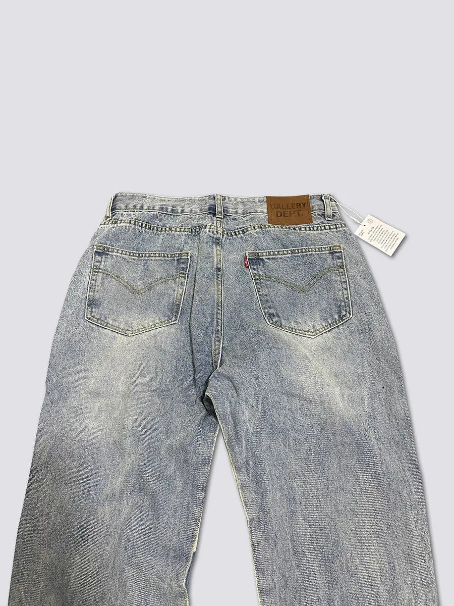 Die Rückseite der hell gewaschenen Patchwork-Denim-Glockenjeans mit einem verblasst-abgenutzten Look und klassischen Rückentaschen