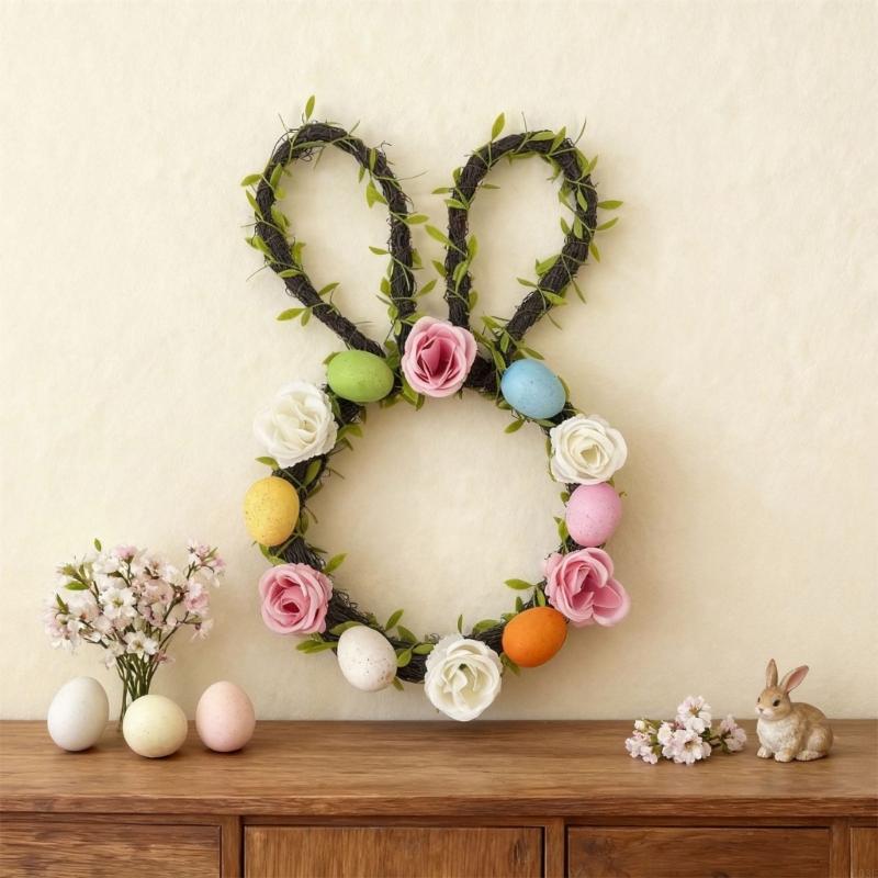 Easter bunny floral wreath for front door made of dark green woven vines decorated with artificial pink white roses and pastel painted eggs.