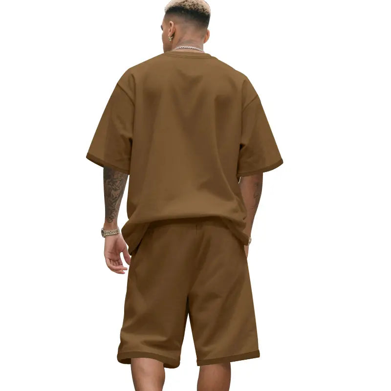 Camiseta oversize marrón con ajuste relajado y mangas cortas, como parte del conjunto veraniego casual para hombre de dos piezas, camiseta y pantalones cortos