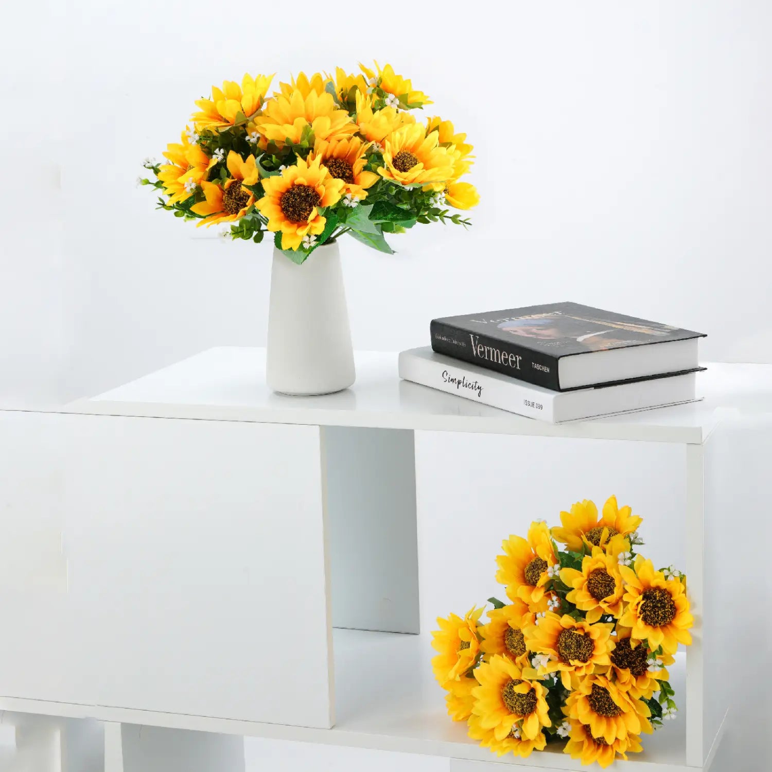 Kunstblumenstrauß aus Sonnenblumen mit leuchtend gelben Blüten, präsentiert in einer eleganten weißen Keramikvase.