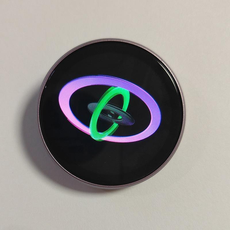 Mini gadget smart desktop companion featuring a circular smartwatch face with a black display, silver metallic bezel, and glowing neon green and purple orbital rings with a data cable included.