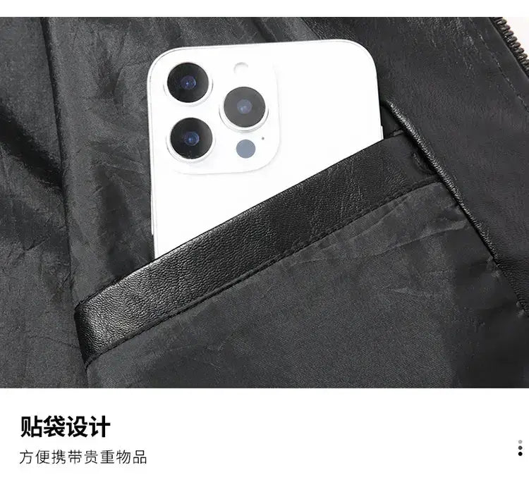 a white smartphone with a triple-camera system resting in the black leather-lined pocket of a men’s light green faux leather moto jacket