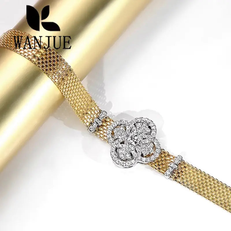 Crystal flower gold mesh cuff bracelet featuring a gold mesh design and a sparkling diamond-encrusted clover-shaped clasp.