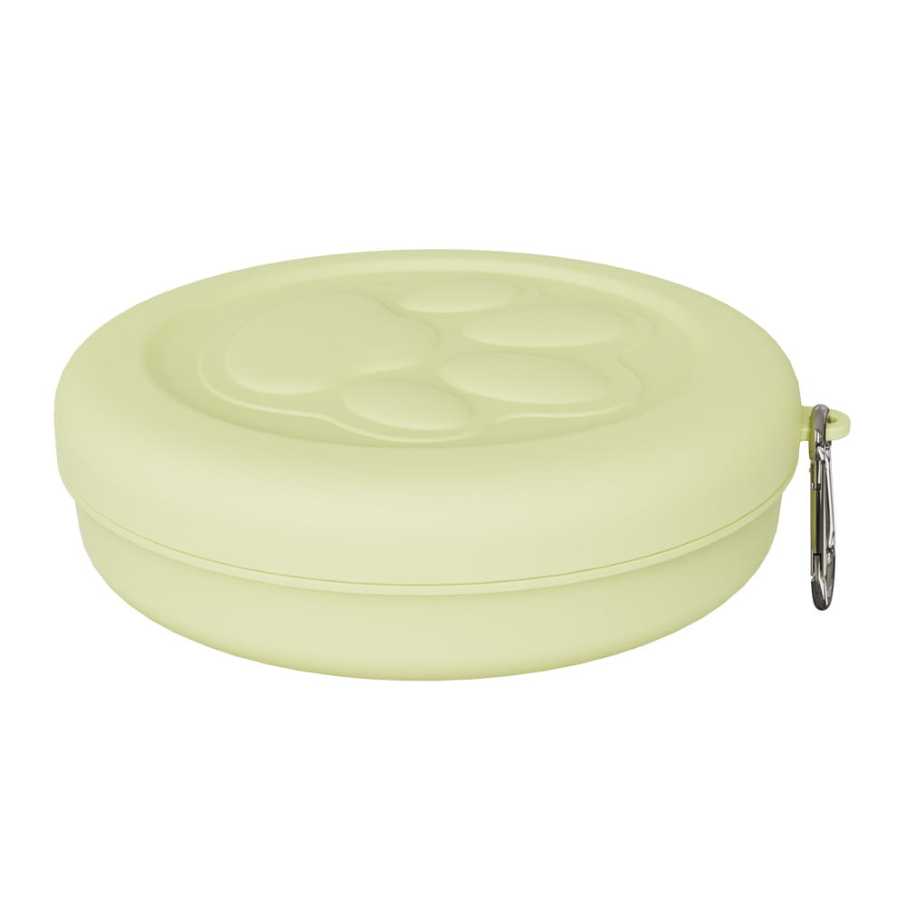Cuenco portátil de silicona color verde pálido para viajar con perros con un diseño de huella de pata y un clip de mosquetón plateado para el almacenamiento de golosinas.