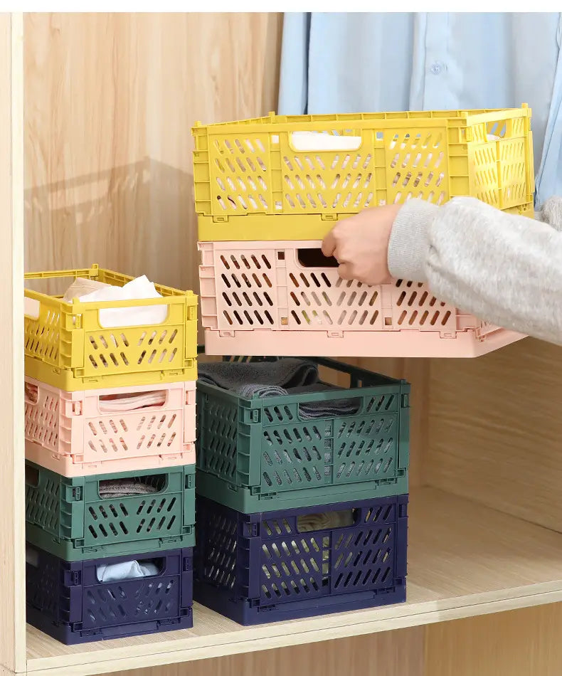 a stack of colorful foldable storage baskets in pastel yellow pink green and navy blue made of plastic with diamond-patterned ventilation holes
