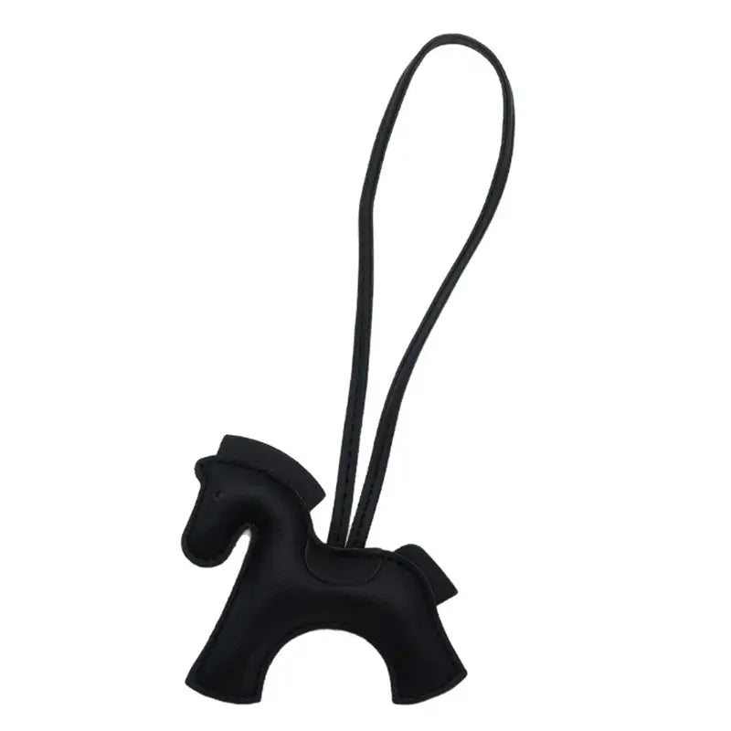 Porte-clés en cuir noir en forme de cheval avec lanière bouclée.