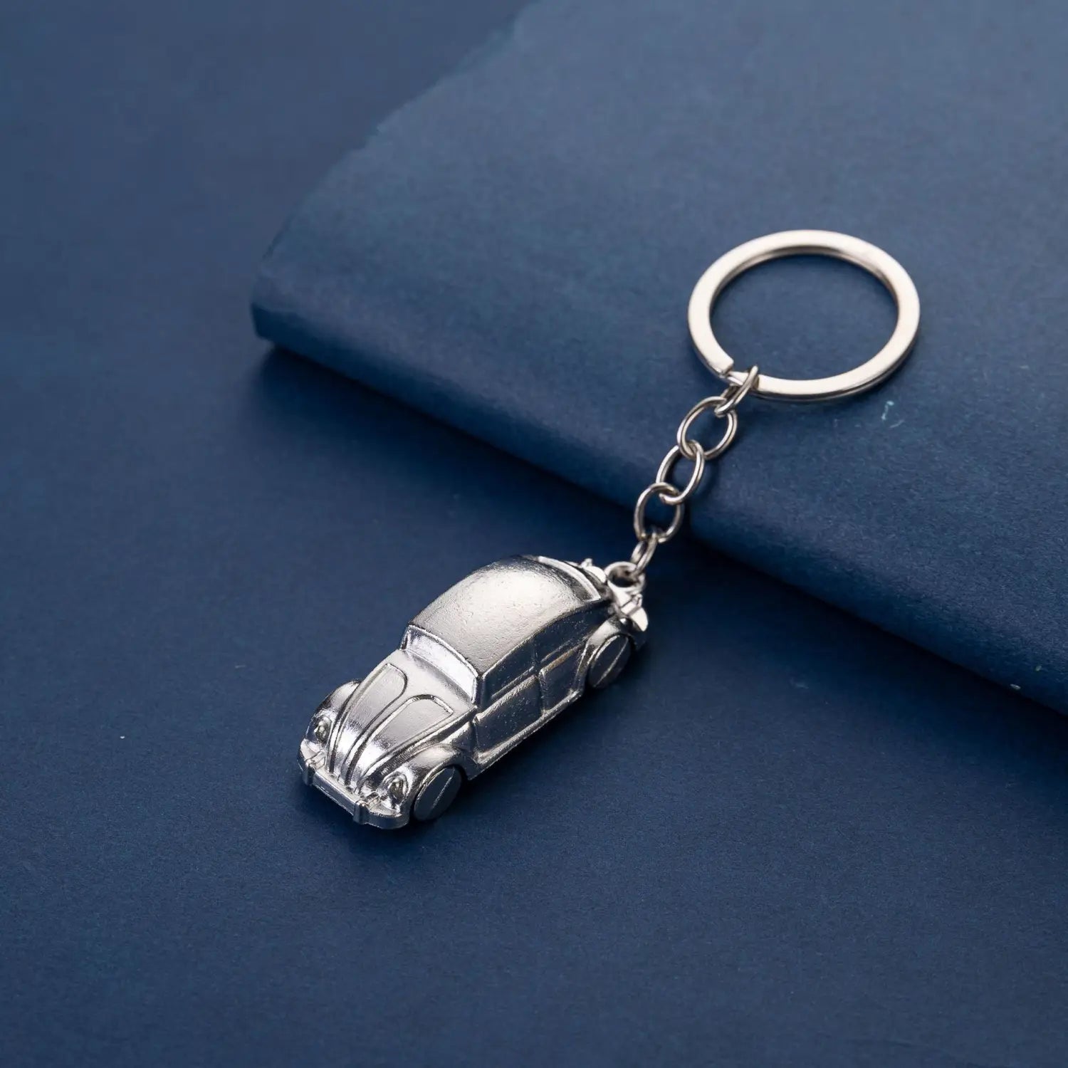 Silver metallic Volkswagen Beetle metal car keychain featuring a detailed miniature car design.