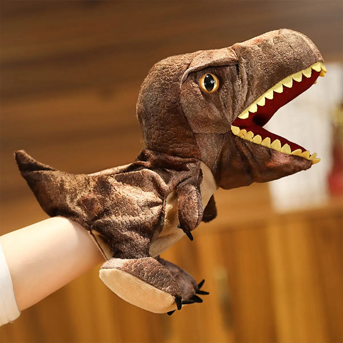 黄色い歯と黒い目を備えた茶色のぬいぐるみティラノサウルス(ティーレックス)恐竜の手人形で、手に装着して遊ぶことができるインタラクティブなおもちゃ。