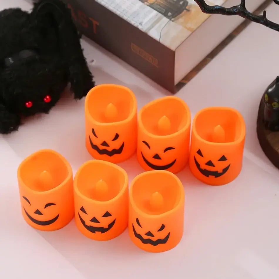 Set of six orange plastic led halloween pumpkin lights shaped like candles with black jack-o-lantern faces.
