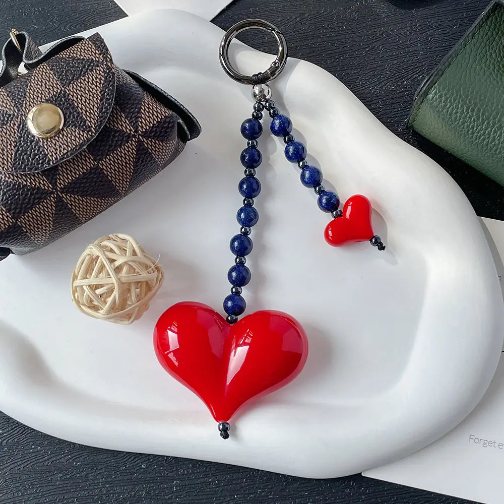 Porte-clés en forme de cœur rouge brillant, pendentif pour sac à perles, avec une chaîne de perles bleu foncé, une plus petite perle assortie rouge et un anneau en argent.