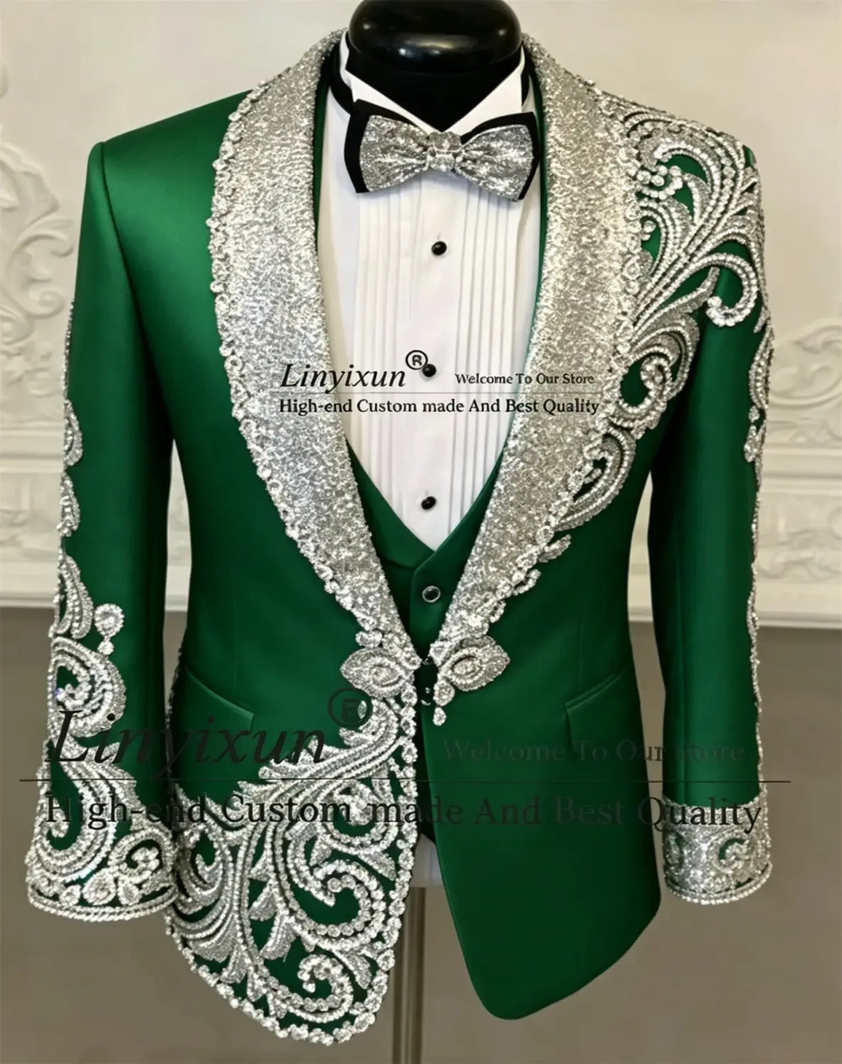 Veste de tuxedo vert émeraude, avec broderie argentée complexe de perles sur les revers, les épaules et les poignets, présentée dans un costume de tuxedo de mariage pour hommes en velours noir à sequins brodés de perles.