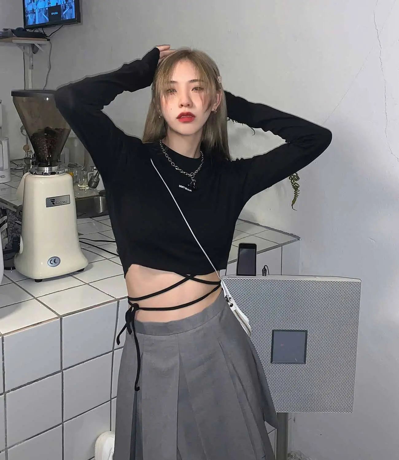 Schwarzes Langarm-Crop-Top aus weichem Stoff mit Crisscross-Frontbindungen, für Damen entworfen.