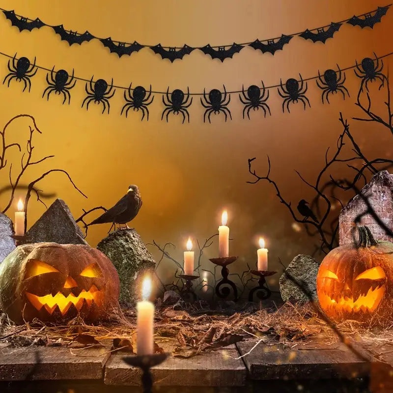 Dos calabazas de color naranja talladas con caras luminosas se colocan sobre una superficie de madera rústica, rodeadas de velas encendidas y decoraciones inquietantes para una exhibición de guirnalda decorativa de papel con purpurina para Halloween.