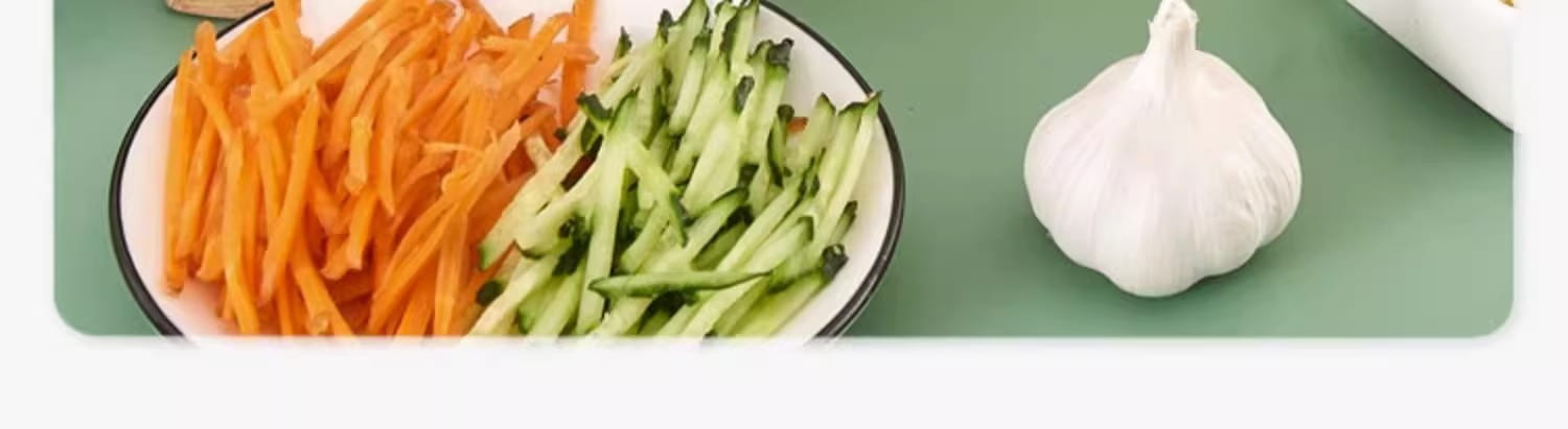 A white garlic bulb with a papery skin and pointed top beside sliced orange carrots and green cucumbers demonstrating a multi-functional stainless steel vegetable slicer shredder for efficient food preparation.