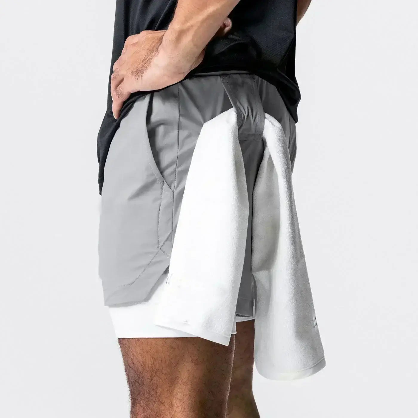 Hombres, pantalones cortos atléticos de dos capas grises y blancos 2 en 1 para gimnasio con un diseño moderno y elegante, que incorporan cintura elástica y trabilla para la toalla para uso en entrenamientos.