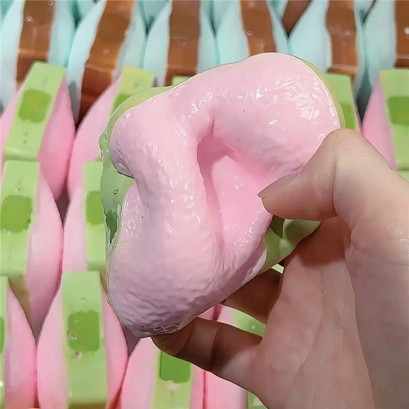 Rosa- und grünfarbener Butterstick als ASMR-Sensory-Squishy-Spielzeug mit einer glänzend glatten Textur zur Stresslinderung