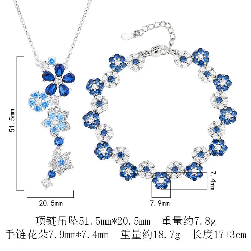 シルバーカラーの花ジルコンのネックレスおよびブレスレットセット。シルバーに、複雑なブルーおよびクリアのクリスタル花モチーフをあしらっています