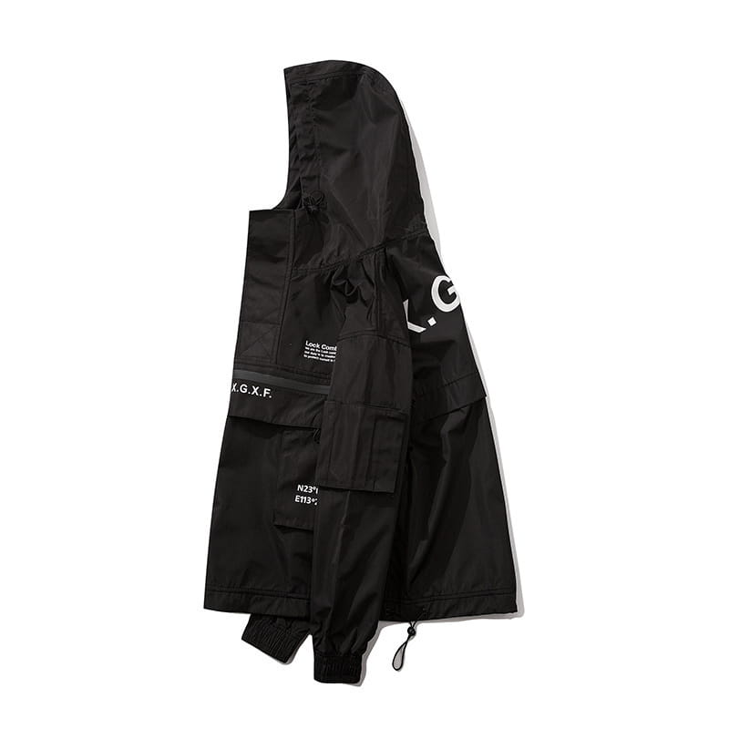 Veste tactique techwear noire à capuche, avec de multiples poches et un lettrage blanc sur les manches, conçue pour une protection imperméable.