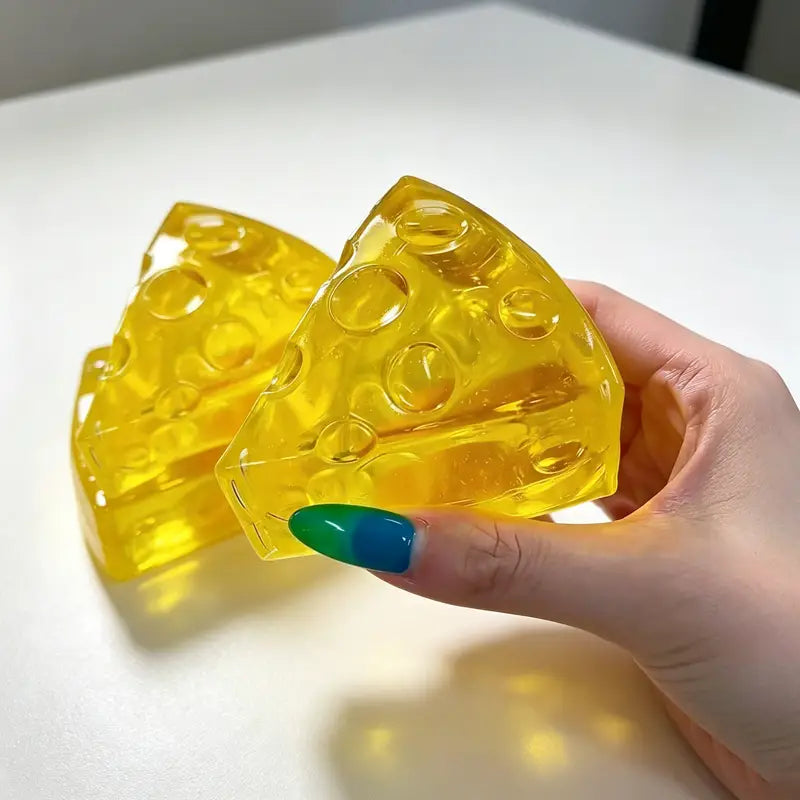 vibrant yellow translucent mini triangle cheese fidget soap with embedded bubble-like holes designed as a soft stress relief squeeze cheese fidget toy