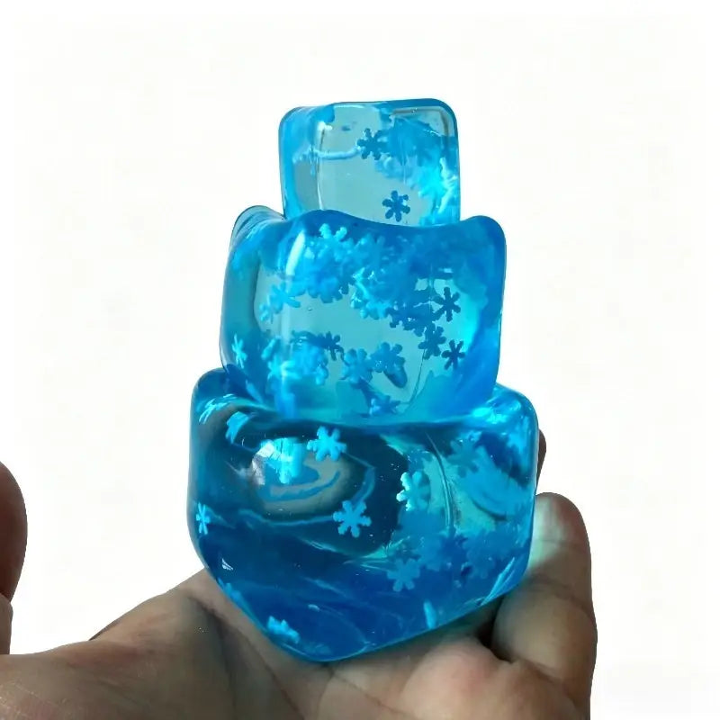 ein Stapel blauer durchscheinender Harz-Eiswürfel Stressabbau-Spielzeuge mit eingebetteten Schneeflocken-Designs, von vorne betrachtet