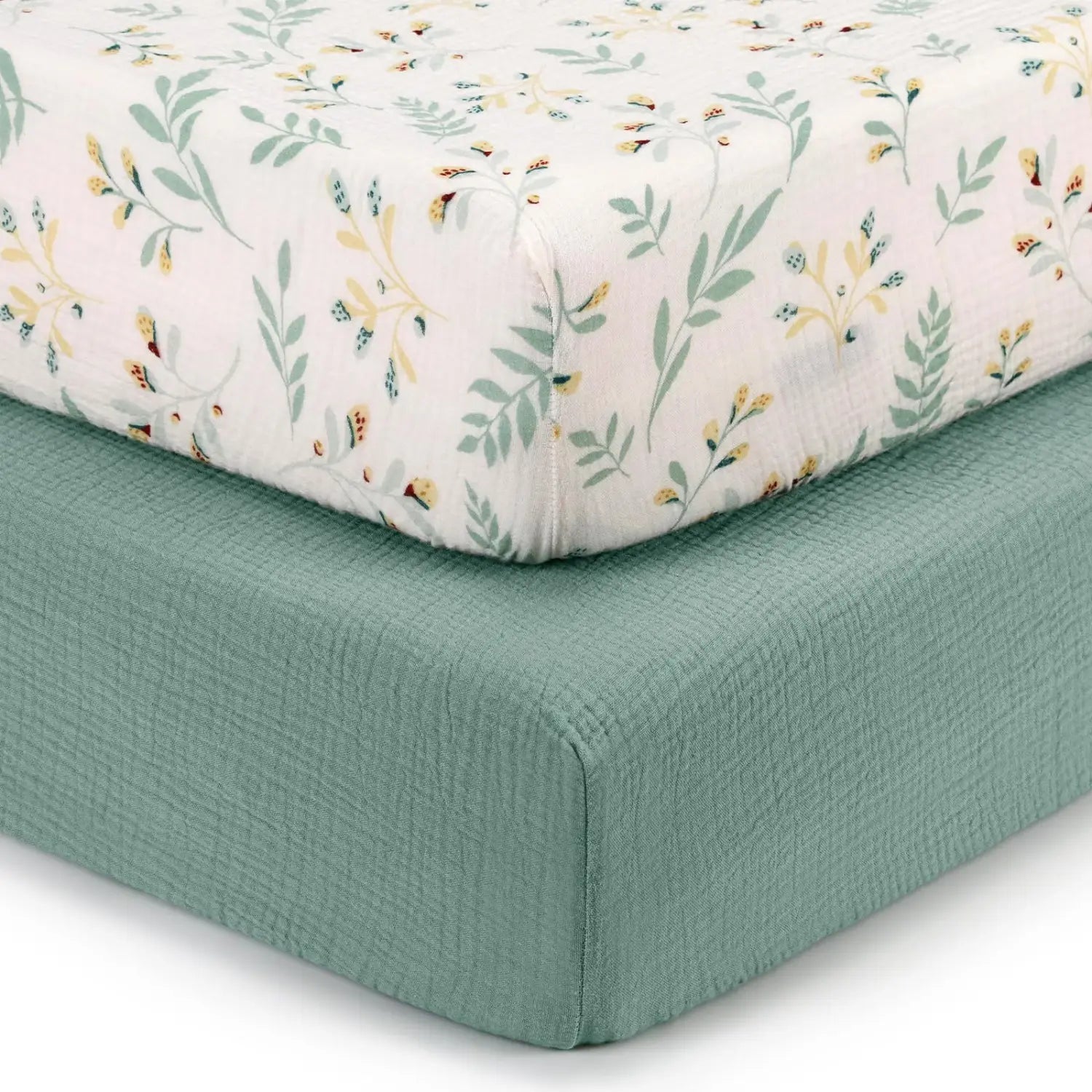 ein zartes Babybettlaken-Set aus weißem Baumwollmuslin, verziert mit einem weichen botanischen Druck in gedämpftem Salbeigrün und hellen Gelbtönen, mit einer dezenten Textur.