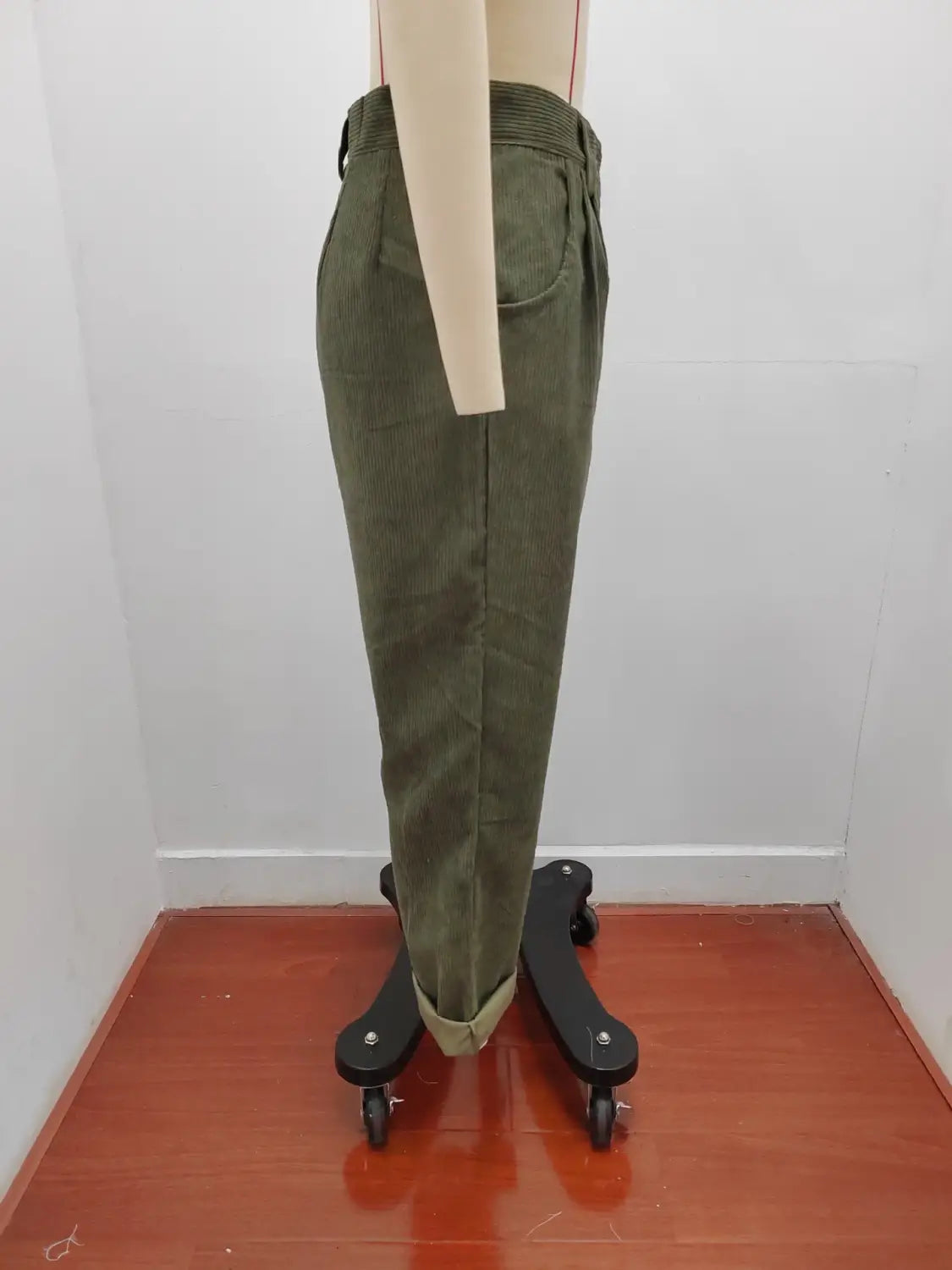 Pantalon en velours côtelé vert olive taille haute ample avec coupe décontractée et bas retroussés, présenté de face