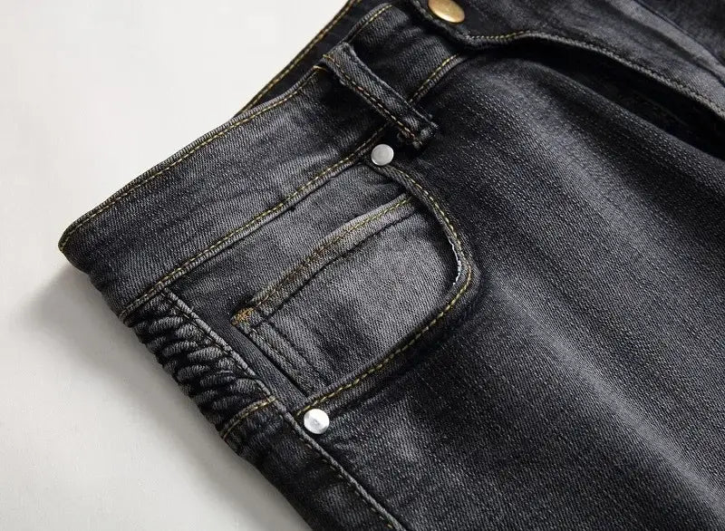 Jeans de moto pour hommes, coupe slim délavée, en denim foncé, avec un design classique à cinq poches et des surpiqûres contrastées.