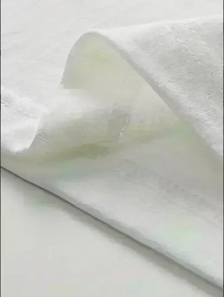 A soft white cotton towel with a subtle woven pattern and gentle folds featured alongside a funny quote cotton t-shirt.