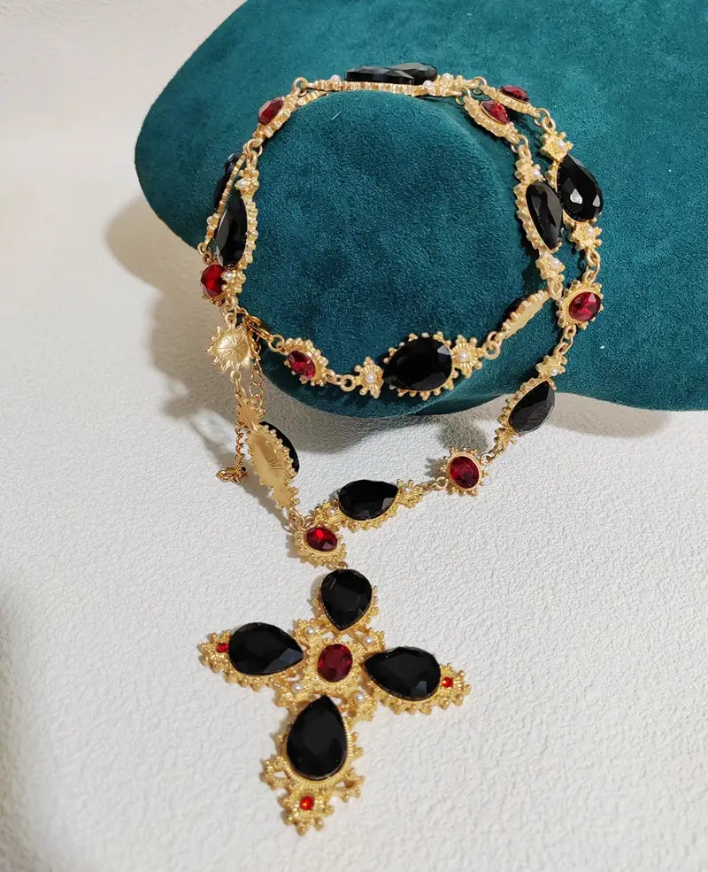 Collier ras du cou à déclaration en cristal à finition dorée, orné d’un pendentif en forme de croix, agrémenté de pierres noires en forme de larme et de pierres rondes rouges, pour des bijoux de soirée.