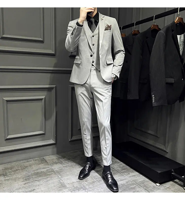 Ensemble de costume trois pièces slim fit gris clair, élégant et épuré, avec une texture discrète, comprenant 9 pantalons courts à la cheville et une fermeture par boutons.