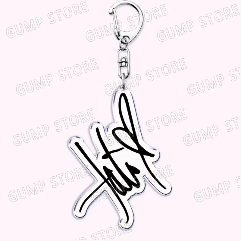 Silver acrylic keychain featuring a stylized signature design with black ink detailing for Tate Mcrae music fan gift