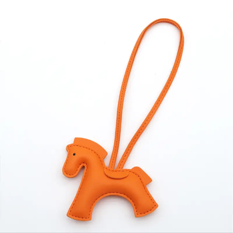 Porte-clés en cuir orange en forme de cheval avec détails cousus et boucle assortie.