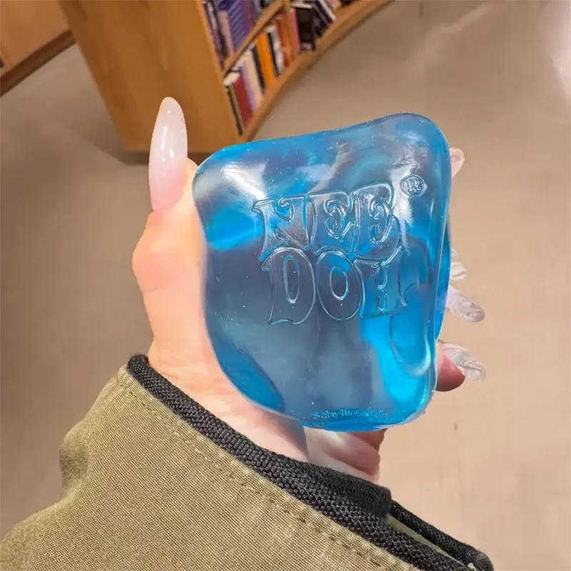 A translucent blue squishy cube fidget toy with embossed neb doh logo viewed from the front