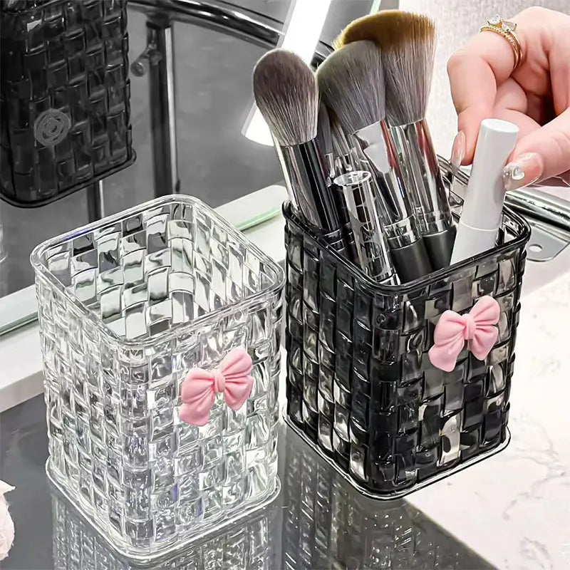 Bow pen holder desktop storage organizer featuring clear and black woven mesh makeup brush holders each adorned with a pink bow.