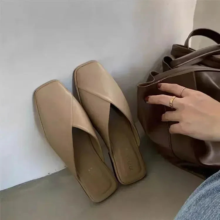Mules plates beige à bout carré pour femmes, au design minimaliste épuré et à la finition en cuir souple, idéales pour des tenues d’été décontractées.