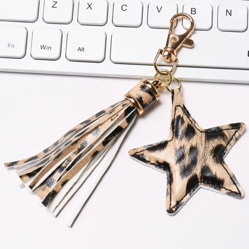 Star leather tassel keychain for women featuring a leopard-print star shape with faux leather straps and a gold-tone metal clasp.