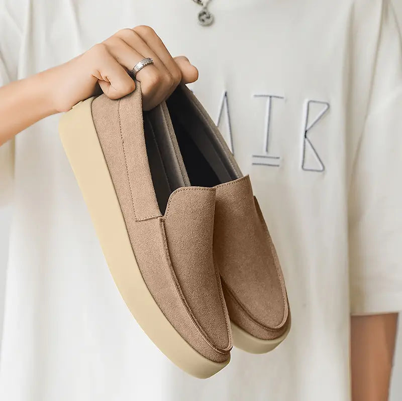 Beige suede slip-on loafers for men featuring a thick off-white rubber sole designed for casual walking.