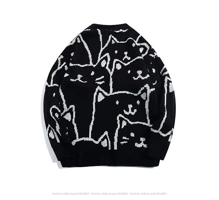 Pull ample en maille noire, doté d’un motif graphique audacieux en traits blancs représentant des chats de dessin stylisés dans un style Harajuku.