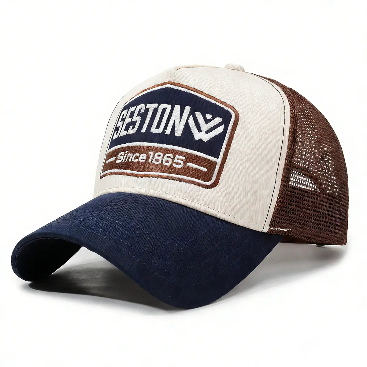 Cream and navy blue trucker hat with brown mesh back featuring an embroidered seston logo patch since 1865 designed as a baseball cap.