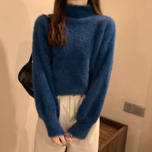 A cozy deep blue fuzzy turtleneck sweater for women with long sleeves made from warm knit fabric ideal for winter wear.