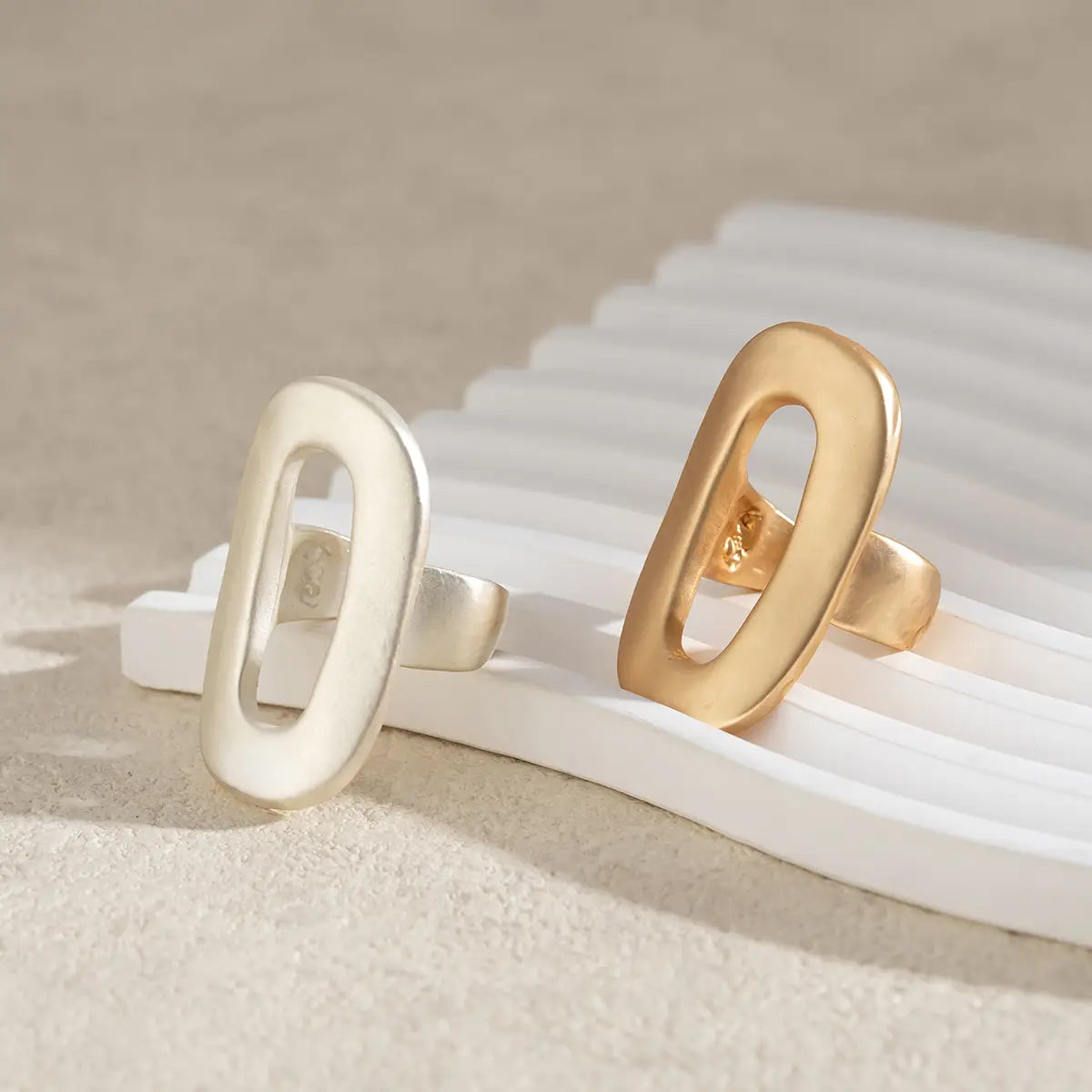 two minimalist geometric oval open ring bands for women in polished silver and gold-tone metal