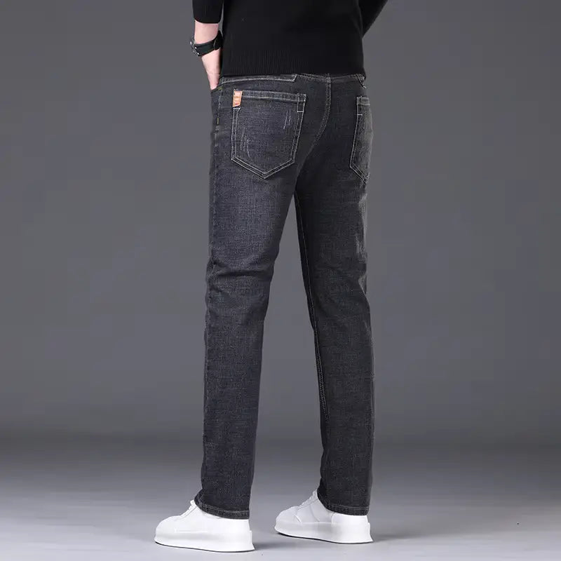 mens stretch denim jeans slim fit casual pants shown from the back in dark-wash denim with slim fit and subtle fading on the back pockets.
