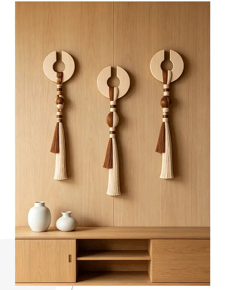 Arte de colgante mural minimalista con borlas tejidas, que presenta tres piezas de madera con tapas circulares, cuentas centrales y borlas de tono de madera natural.