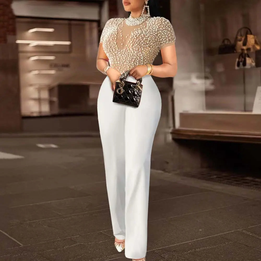 black quilted handbag with gold-tone hardware and distinctive logo paired with beige beaded mesh jumpsuit high waist party outfit