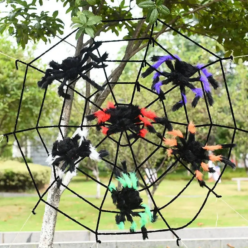 une toile d’araignée décorative d’Halloween avec cinq fausses araignées en peluche noire, chacune rehaussée de pattes duveteuses colorées en violet, rouge, blanc, orange et vert