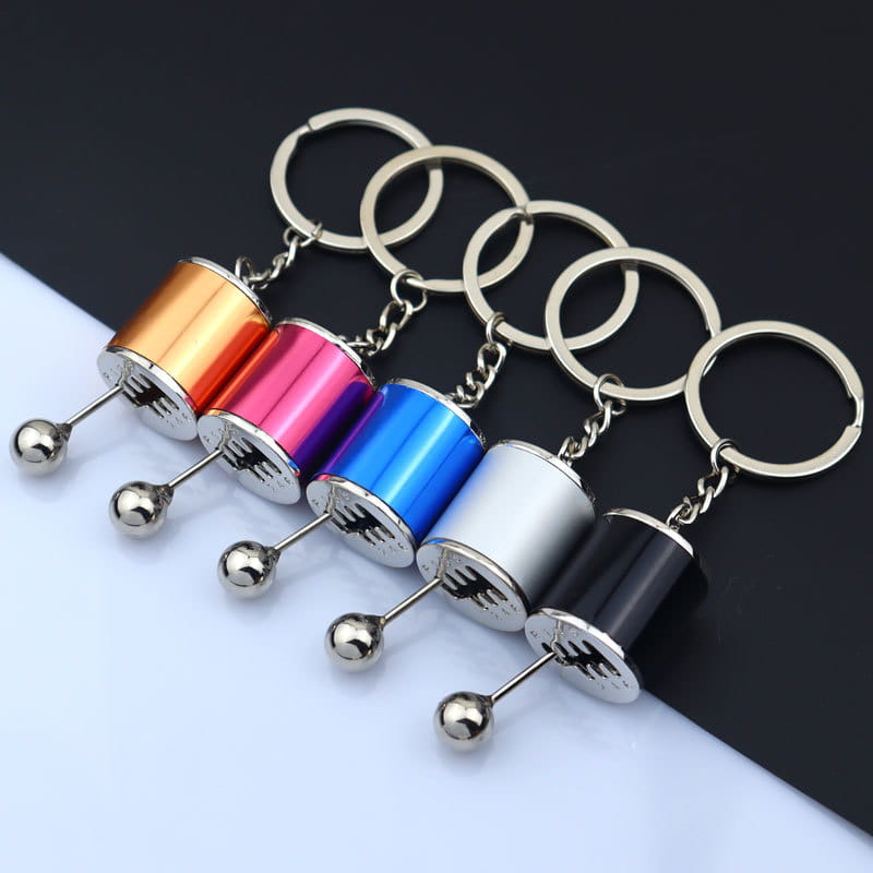 Colorful metallic manual gear shift car keychains with chrome finished spherical ends and engraved detailing.