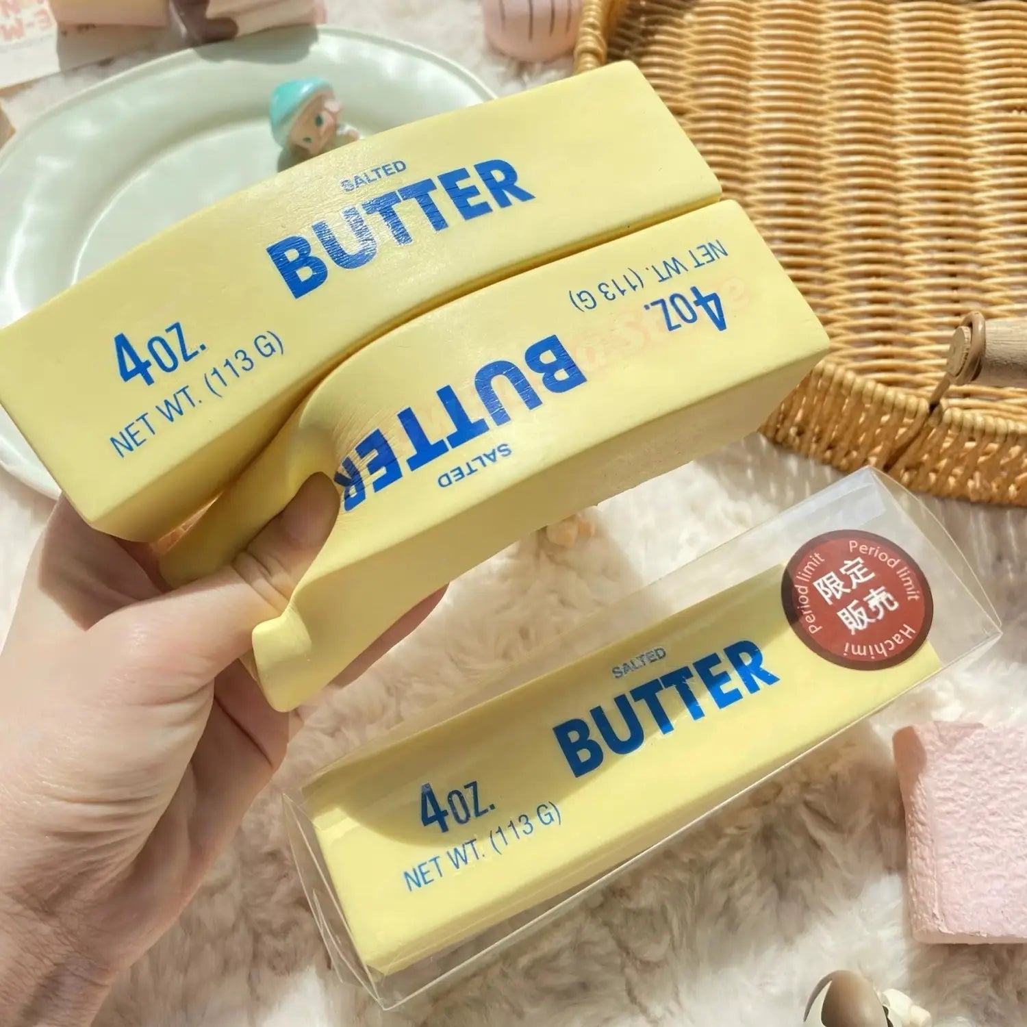 Bâtons de beurre salé jaunes à montée lente, avec lettrage bleu, emballés dans un plastique transparent, conçus comme des jouets antistress à montée lente, en assortiment de 12.